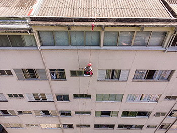 foto aerea de alpinista limpando janela de predio